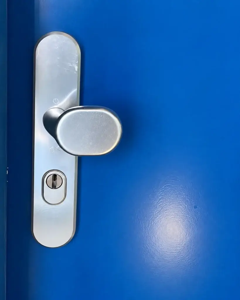 Antikerntrekbeslag op een blauwe buitendeur
